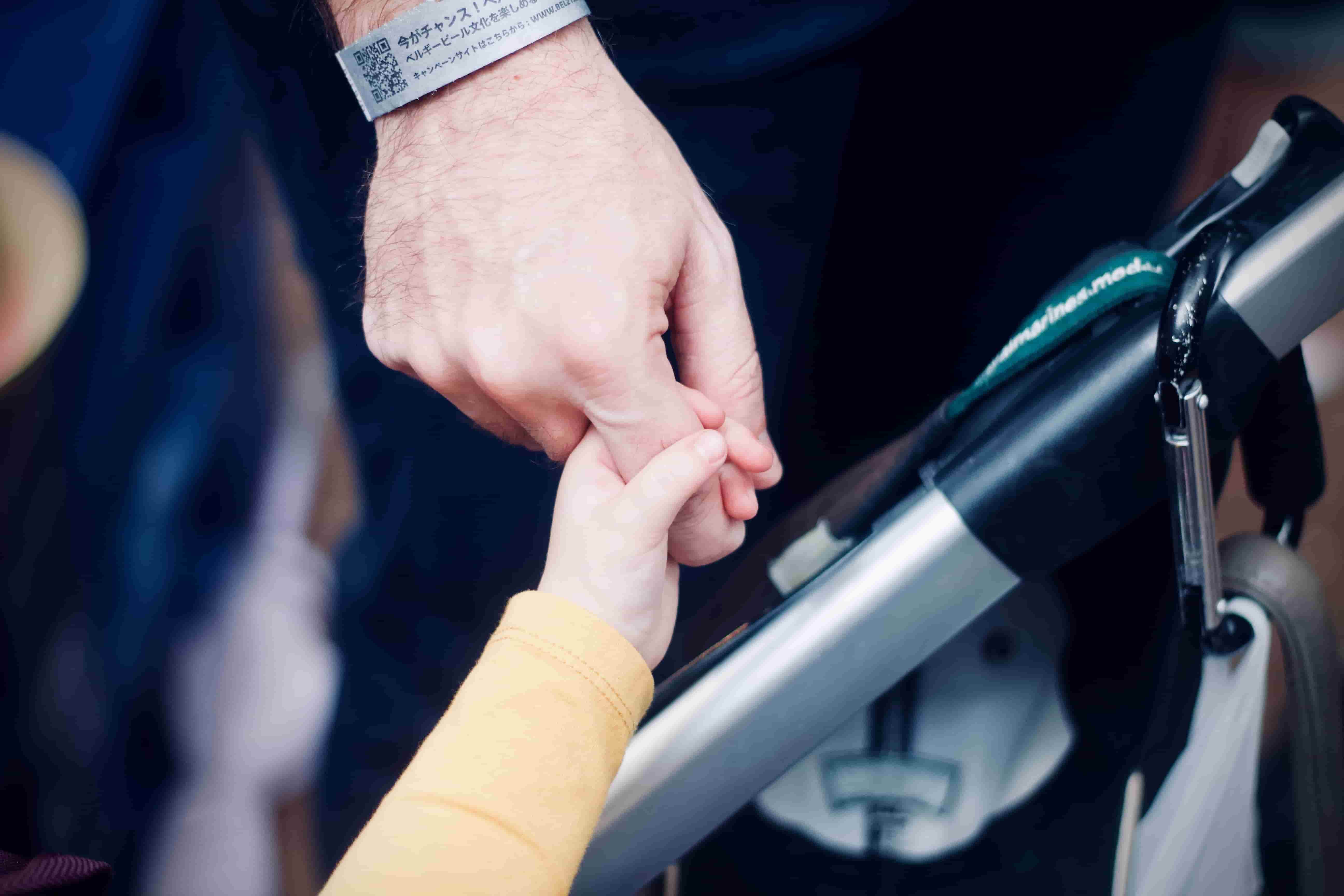 Son holding father's hand