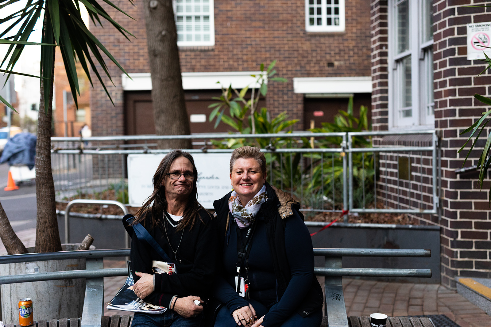 A staff member and visitor sit outside Wayside Kings Cross