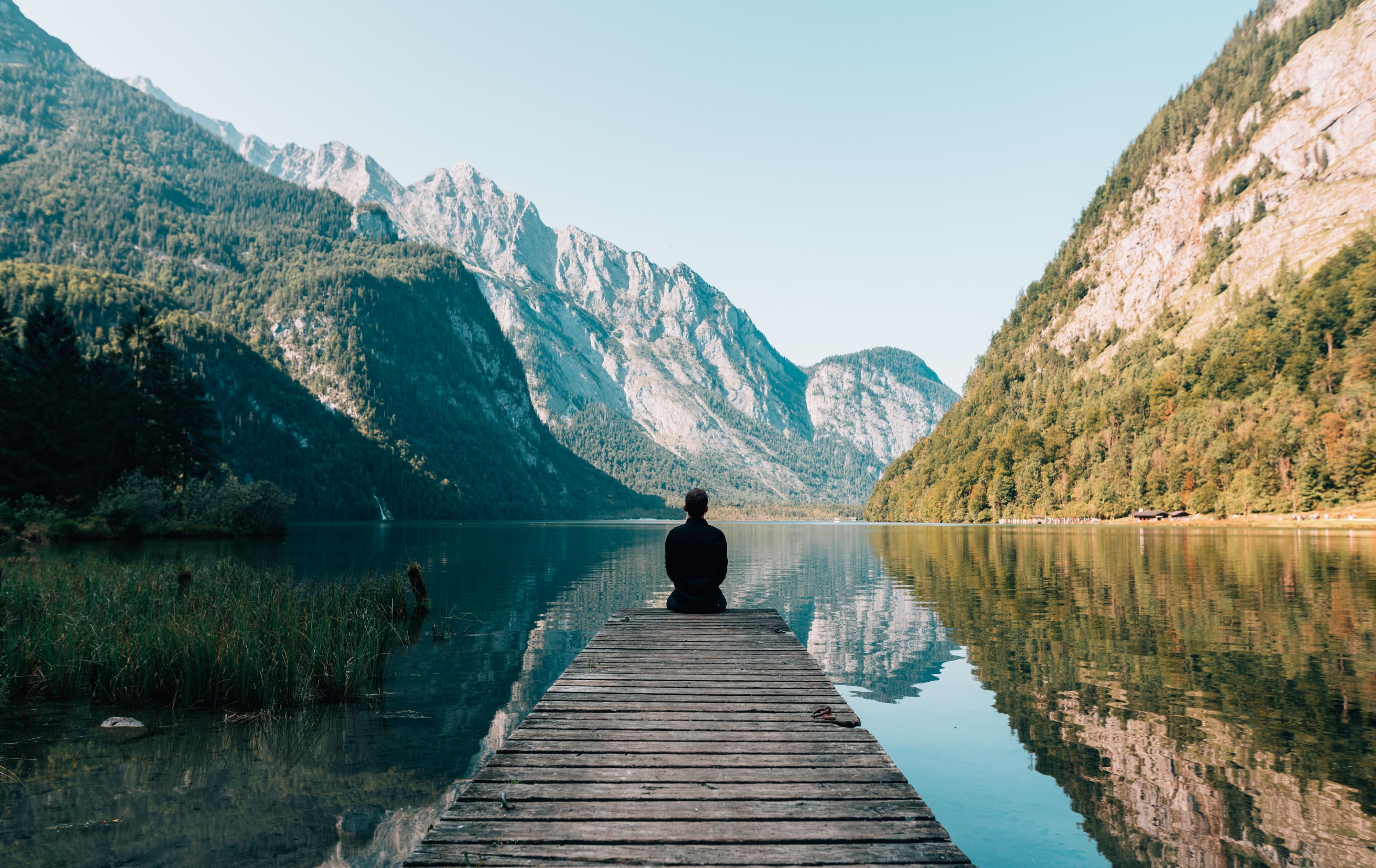 Person sitting on the end of jetty looking out at extraordinary view